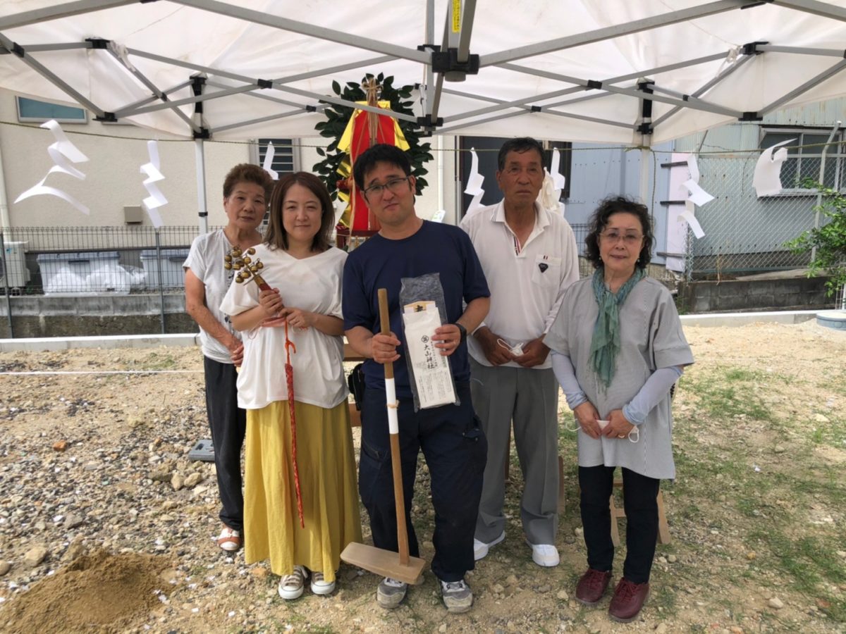 アイデザインホームの現場リポート　地鎮祭の現場リポート　大阪府の工事現場　大阪府で注文住宅ならアイデザインホーム　堺市で注文住宅　鍬と神楽鈴を持った家族写真