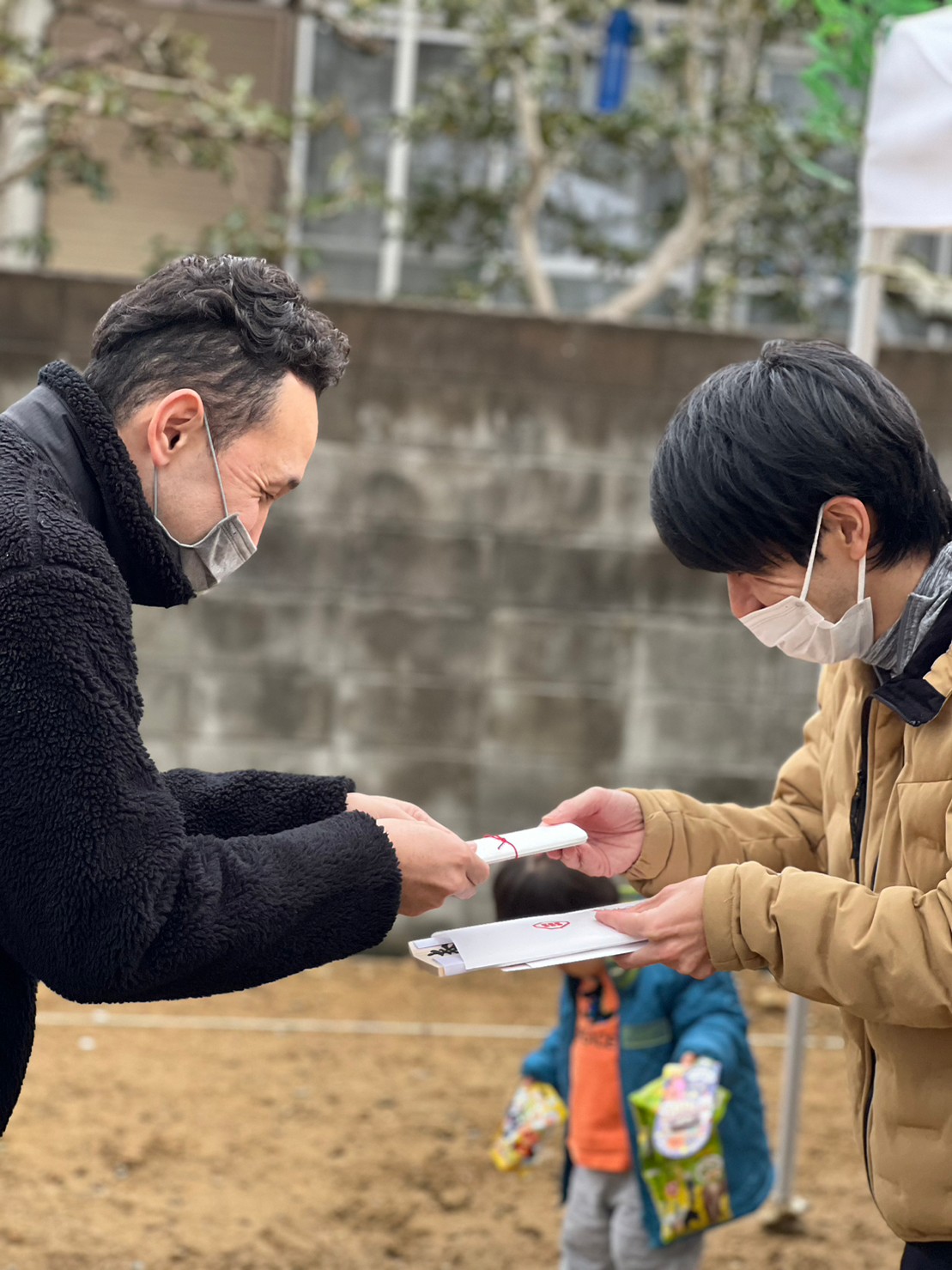アイデザインホームの現場リポート　地鎮祭の現場リポート　兵庫県で注文住宅ならアイデザインホーム　物を渡す男性とそれを受け取る男性