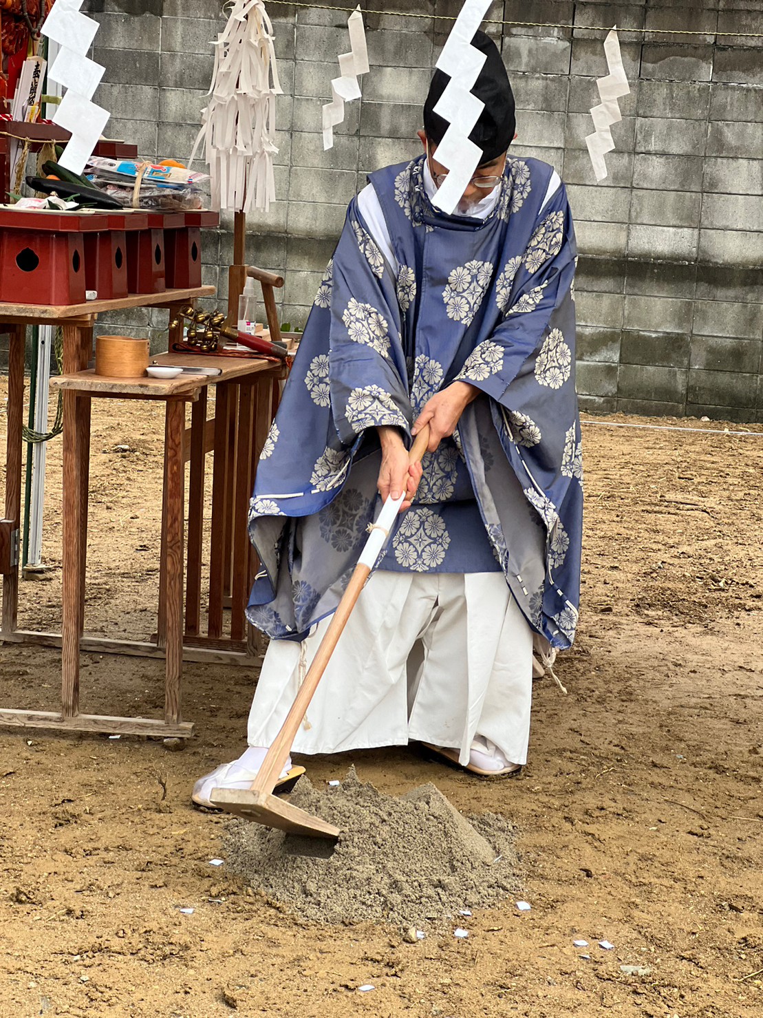 アイデザインホームの現場リポート　地鎮祭の現場リポート　兵庫県で注文住宅ならアイデザインホーム　鍬で盛り砂を崩す神主さん