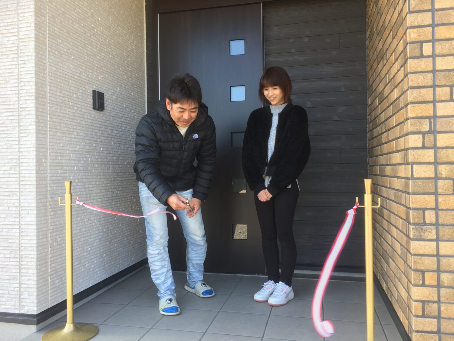 アイデザインホームの現場リポート お引渡しの現場リポート 愛知県の工事現場 愛知県で注文住宅ならアイデザインホーム 男性がテープカットをした瞬間の様子