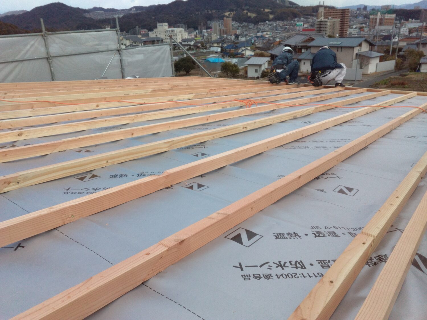 アイデザインホームの現場リポート 上棟の現場リポート 広島県の工事現場 広島県で注文住宅ならアイデザインホーム 屋根の上で作業をする大工さん