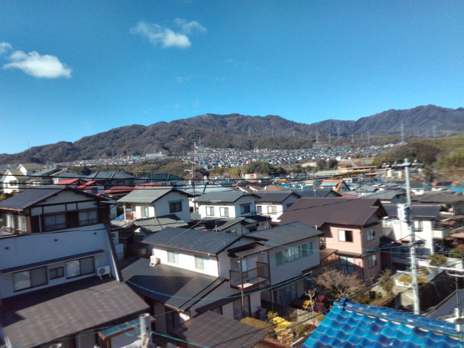 アイデザインホームの現場リポート 上棟の現場リポート 広島県の工事現場 広島県で注文住宅ならアイデザインホーム 遠くの山と団地が見渡せる屋根の上