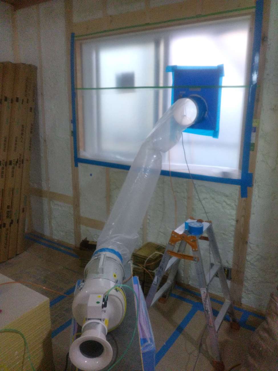 アイデザインホームの現場リポート 気密測定の現場リポート 大阪府の工事現場 大阪府で注文住宅ならアイデザインホーム 窓の外に繋がる気密測定の機械