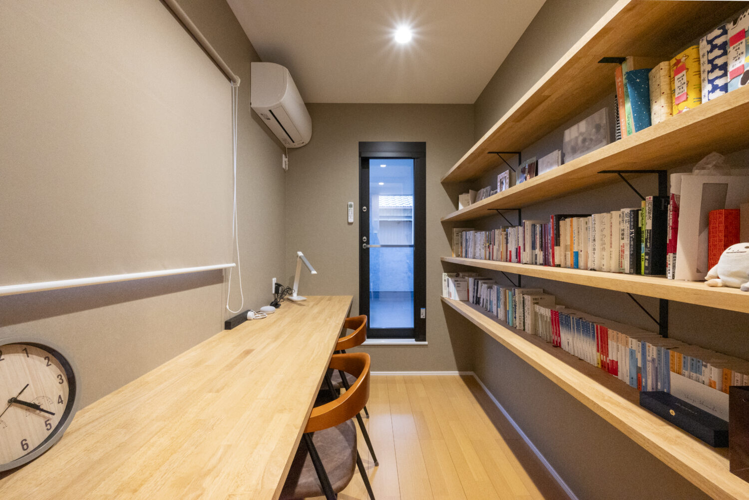 アイデザインホーム
三重の注文住宅　実例
書斎スペースは家族共有の本棚を設け、3人座れるカウンターも有している。
読書や趣味のスペースとして活用でき、奥のドアはバルコニーに繋がる。
