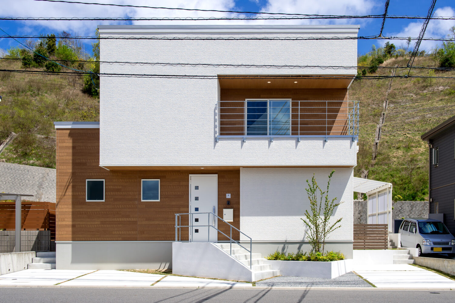 広島の注文住宅ならアイデザインホーム｜真っ白な外壁に木目のサイディングをアクセントに加えた、モダンなデザインの外観