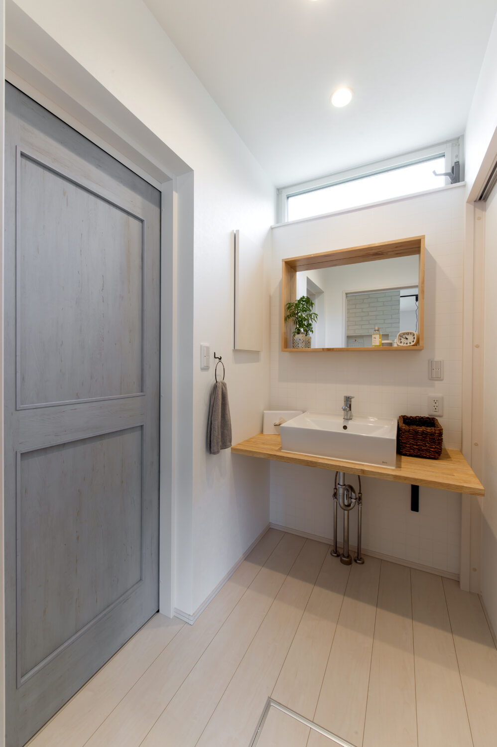 広島県の注文住宅　広島県尾道市の建築実例　広島県で注文住宅ならアイデザインホーム
グレーのある建具　洗面カウンターは造作　大きな鏡がある洗面所