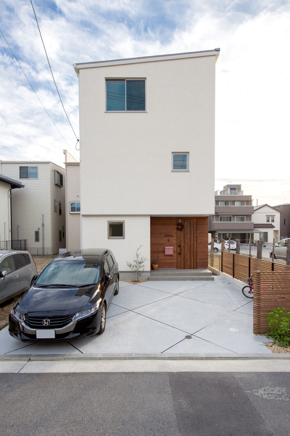広島県で注文住宅　広島市で注文住宅　注文住宅ならアイデザインホーム　広島の建築実例集　ホワイトの外壁の3階建て　玄関は木目にすることでアクセントにしている