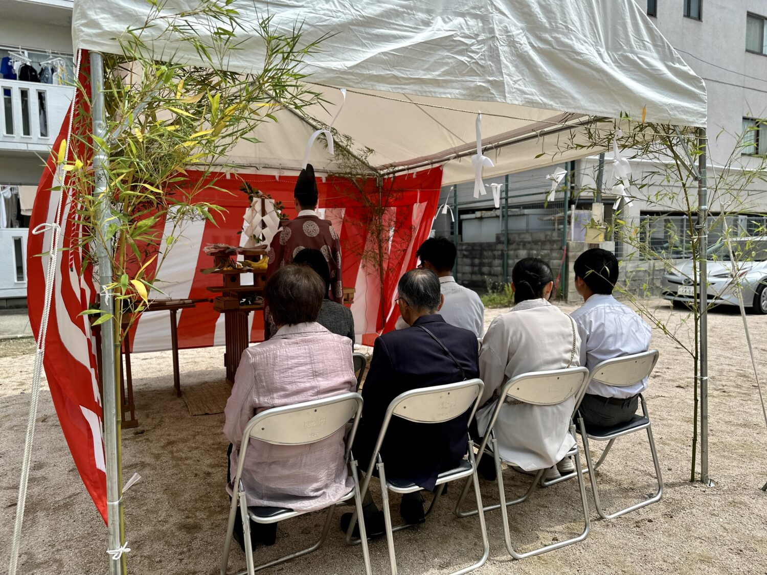 アイデザインホームの現場リポート　広島県で注文住宅ならアイデザインホーム　地鎮祭の現場リポート　テントの下で神主さんが祭壇に向かっている