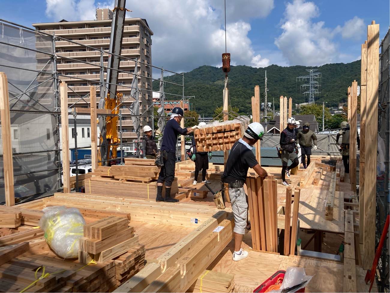 広島で注文住宅ならアイデザインホーム｜上棟の現場リポート｜クレーン車を使って2階まで重たい部材を運び、それを受け取る職人さんたち