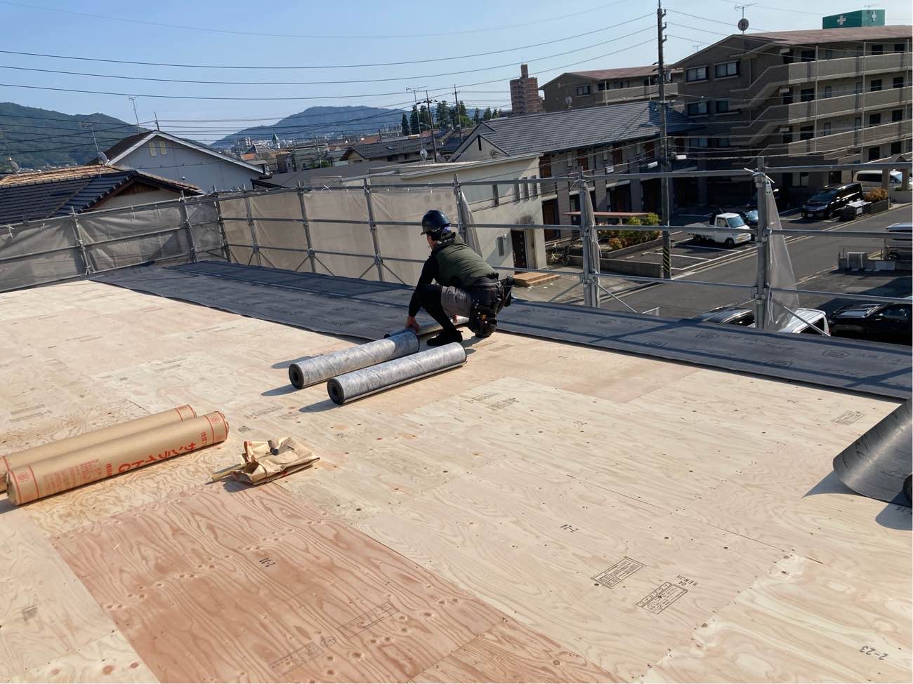広島で注文住宅ならアイデザインホーム｜上棟の現場リポート｜屋根材の上にアスファルトルーフィングを施工している職人さん