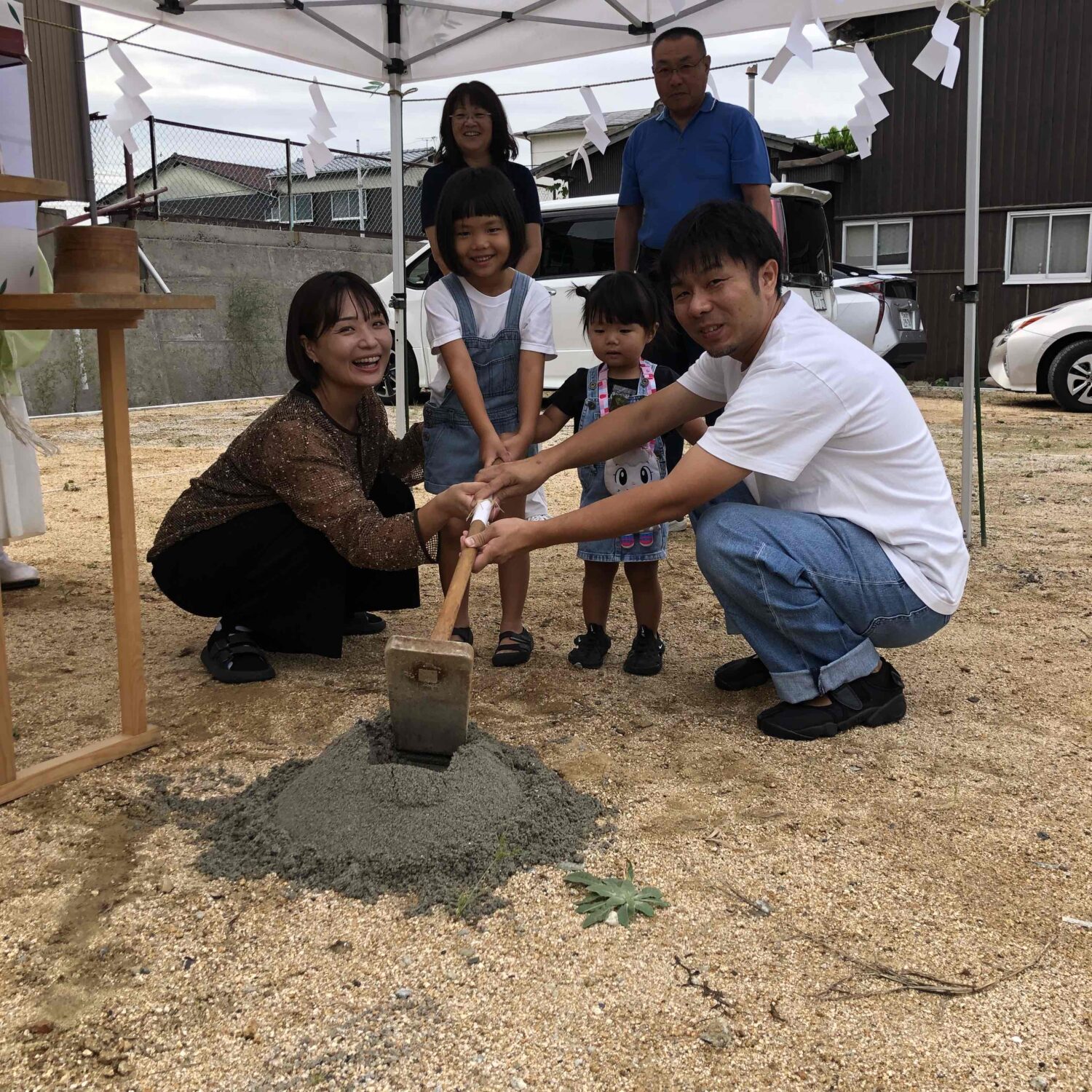 福山で注文住宅ならアイデザインホーム｜地鎮祭の現場リポート｜家族全員で鍬入れの儀を行う様子