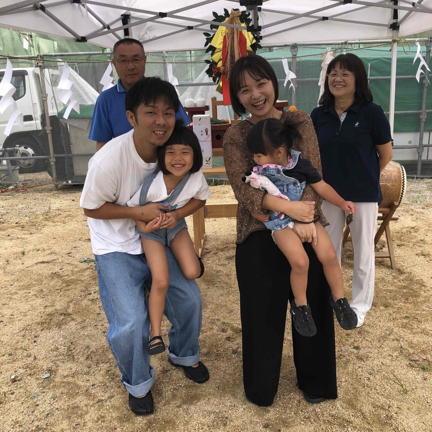 福山で注文住宅ならアイデザインホーム｜地鎮祭の現場リポート｜祭壇前で笑顔で記念撮影をする家族