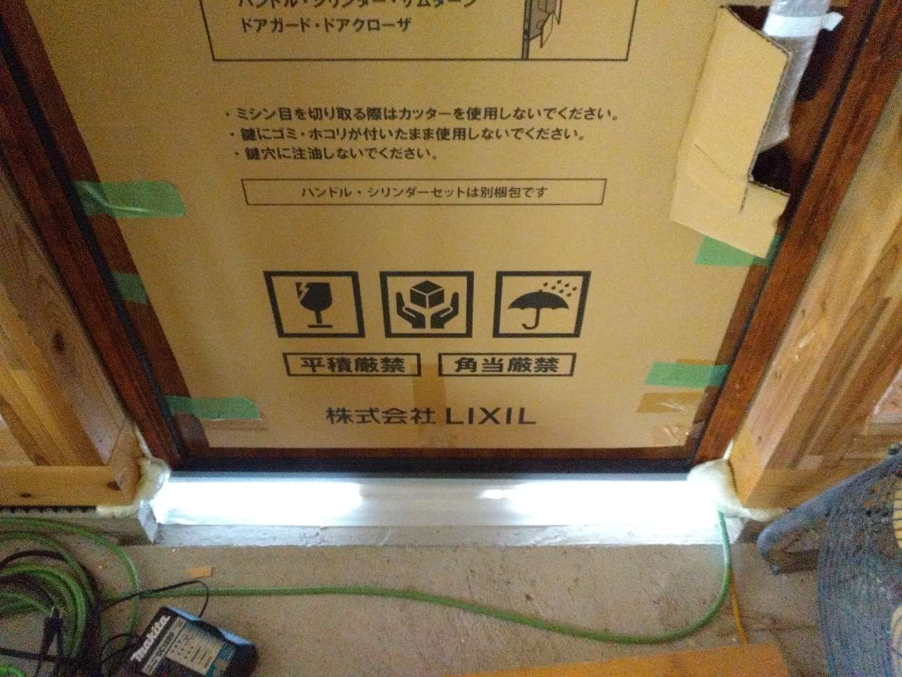 愛知で注文住宅ならアイデザインホーム|気密測定の現場リポート|玄関扉下を気密テープでふさいだ様子