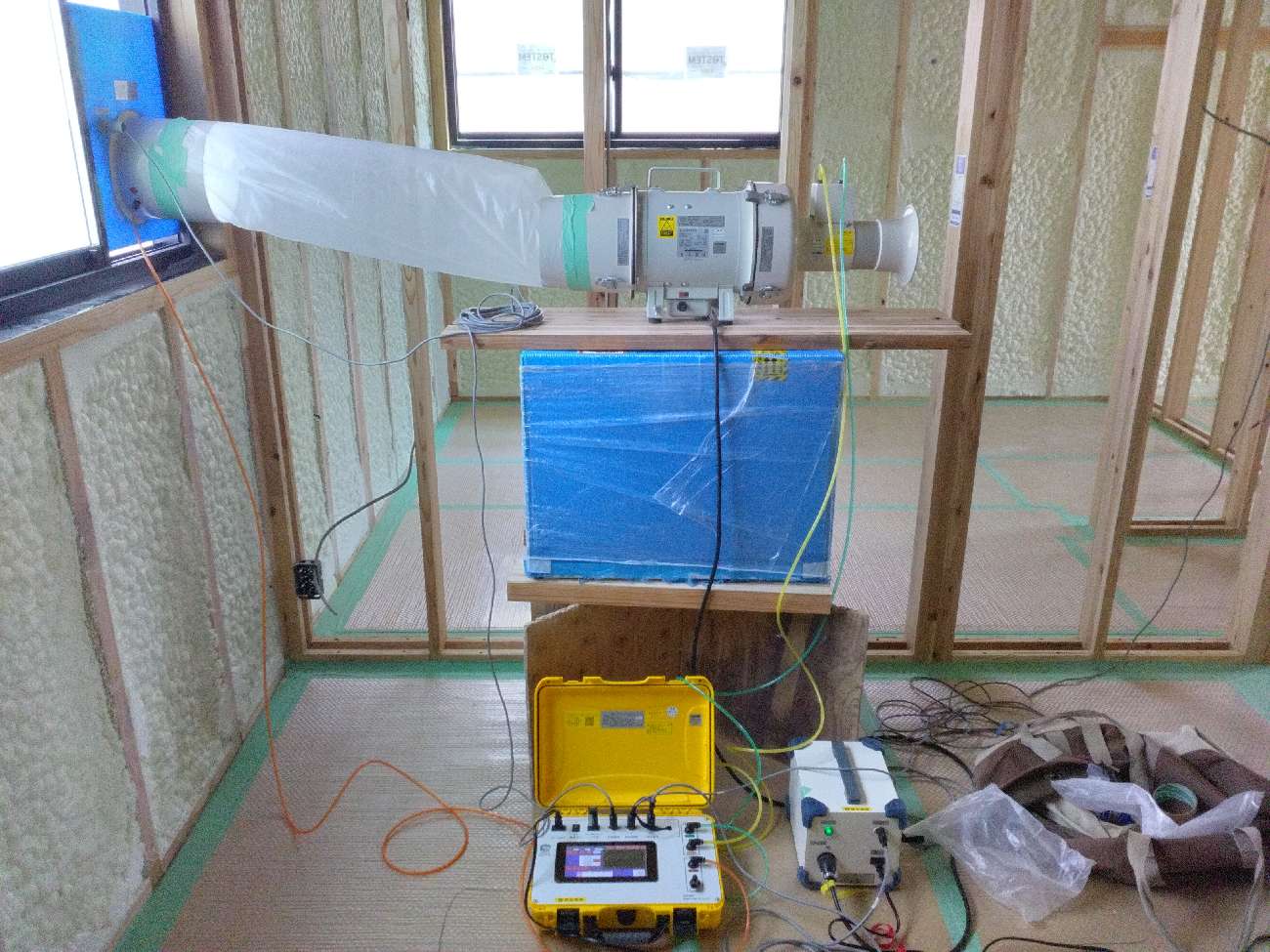 三重で注文住宅ならアイデザインホーム｜気密測定の現場リポート｜気密測定の機械を使い測定を行っている様子