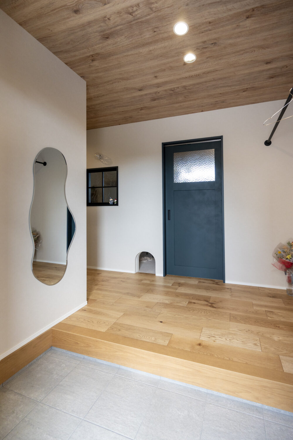 愛犬と暮らすピットリビングのあるジャパンディスタイルの家|アイデザインホーム 玄関を開けると目を惹く小さなアーチ型ののぞき窓