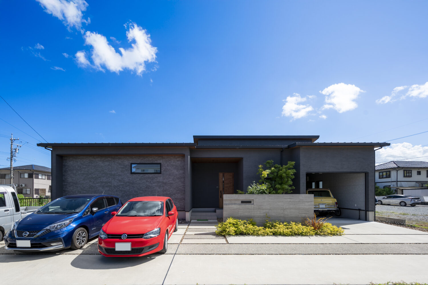 三重で注文住宅ならアイデザインホーム｜アイデザインホームの実例集｜ダークトーンのグレーを基調とした落ち着きのある外観。雨風からお気に入りのヴィンテージカーを守れるよう、シャッター付きのビルドインガレージを設けています