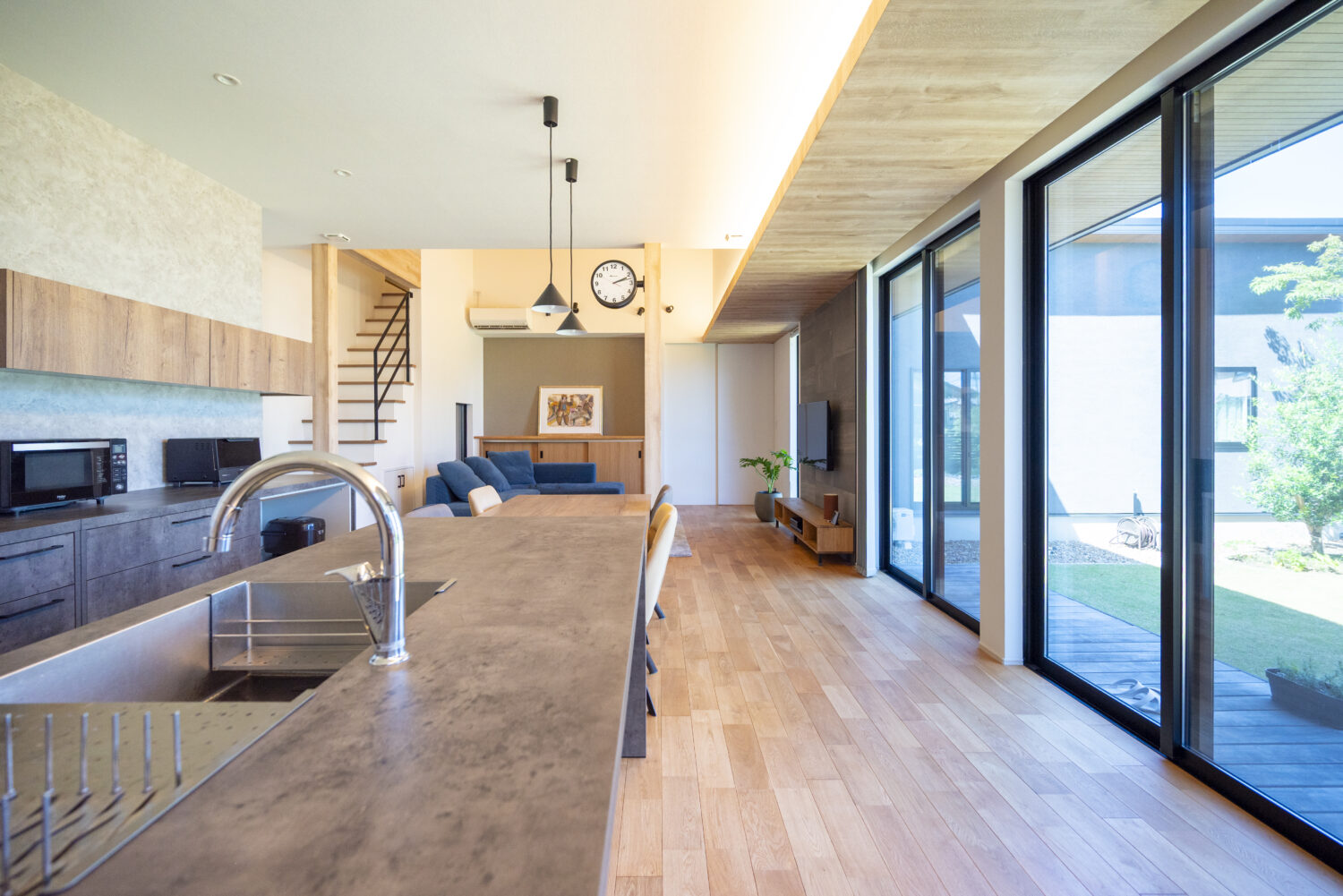 三重で注文住宅ならアイデザインホーム｜アイデザインホームの実例集｜ハイサッシで開放的な室内。玄関から続く木目調の下がり天井は、外の軒天と繋がって見えるよう工夫することで、実際の面積以上の広がりを感じさせます