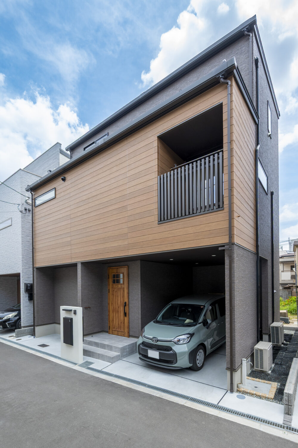 小上がりヌックが家族をつなぐ 24坪の敷地に叶えた3階建ての家｜アイデザインホームの実例集｜チャコールグレーと木目調サイディングを組み合わせたモダンな3階建て