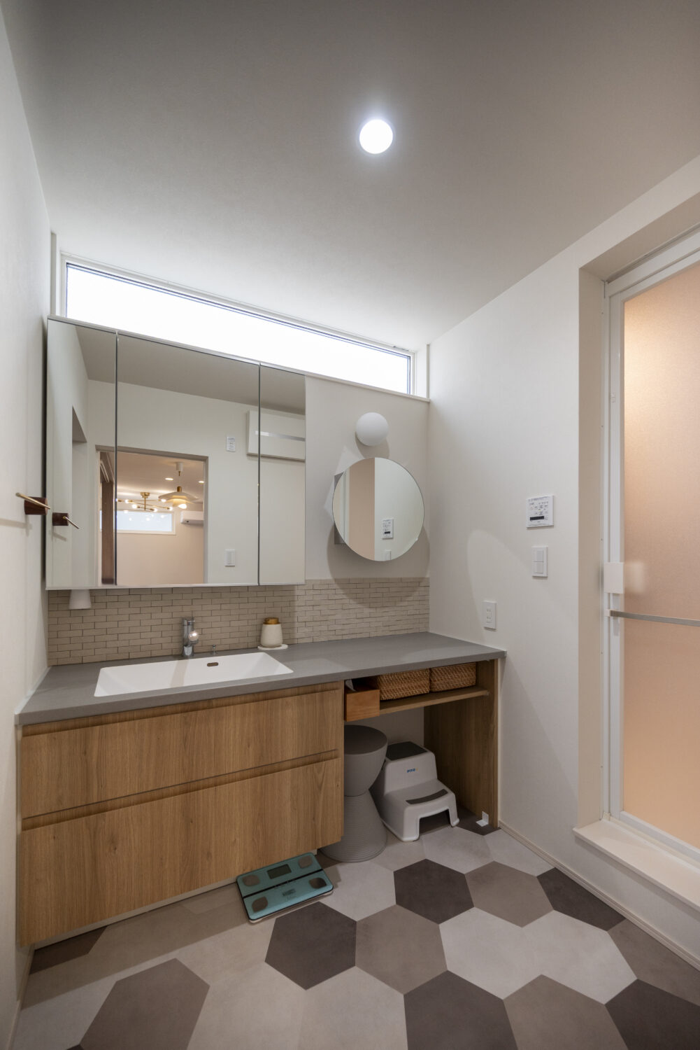 小上がりヌックが家族をつなぐ 24坪の敷地に叶えた3階建ての家｜アイデザインホームの実例集｜1階のセカンド洗面台とお揃いのヘキサゴン型フロアタイルを取り入れた洗面脱衣室