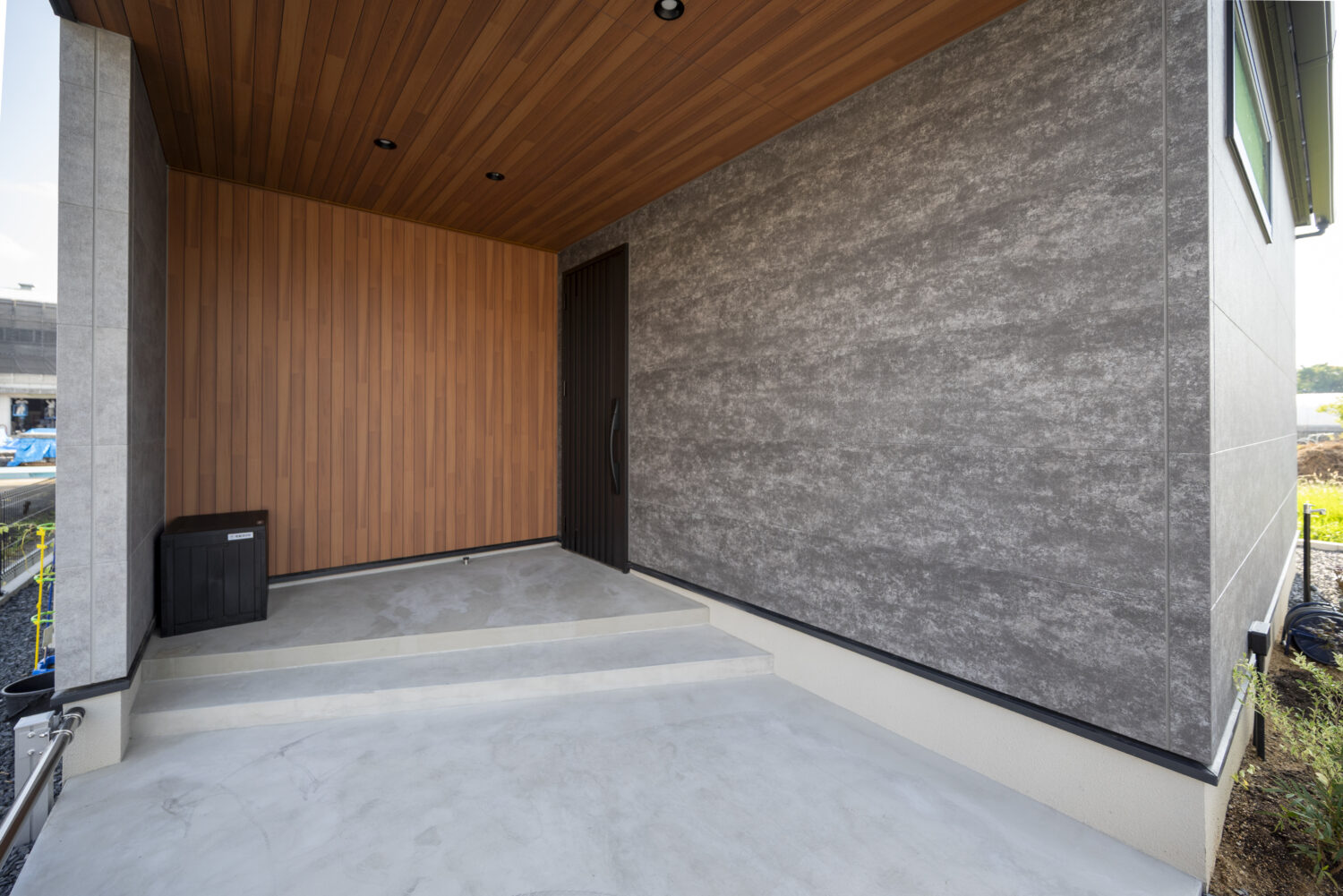 アイデザインホームの施工事例｜家族の距離感が心地よい セカンドリビングのある家｜深く掛けた軒下に自転車を停めるスペースを確保し、機能性と奥行きのあるデザインを両立した玄関ポーチ