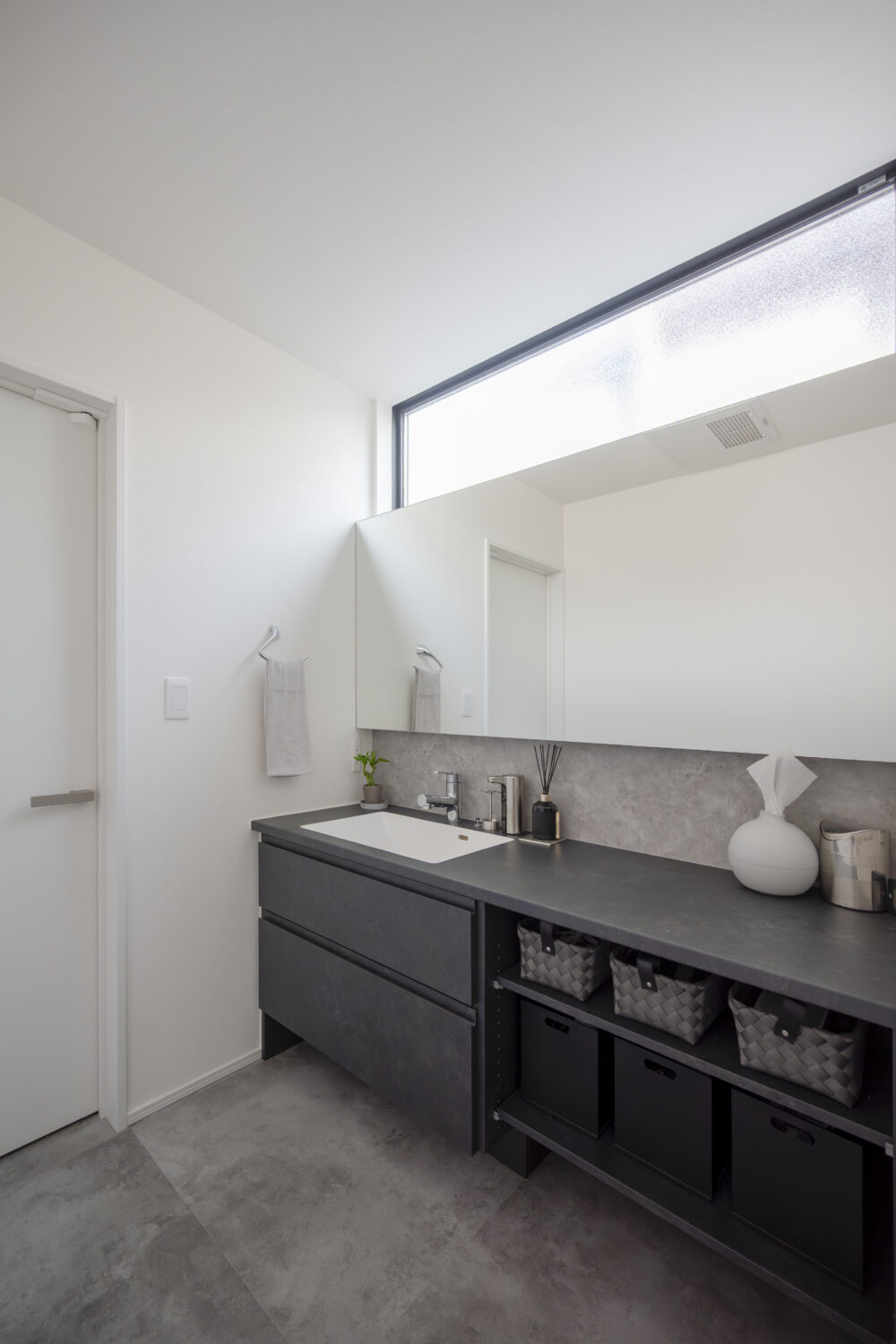 リビング中心で心地よく暮らす ホテルライクな平屋｜アイデザインホーム｜横長のワイドミラーが印象的なすっきりとした洗面室