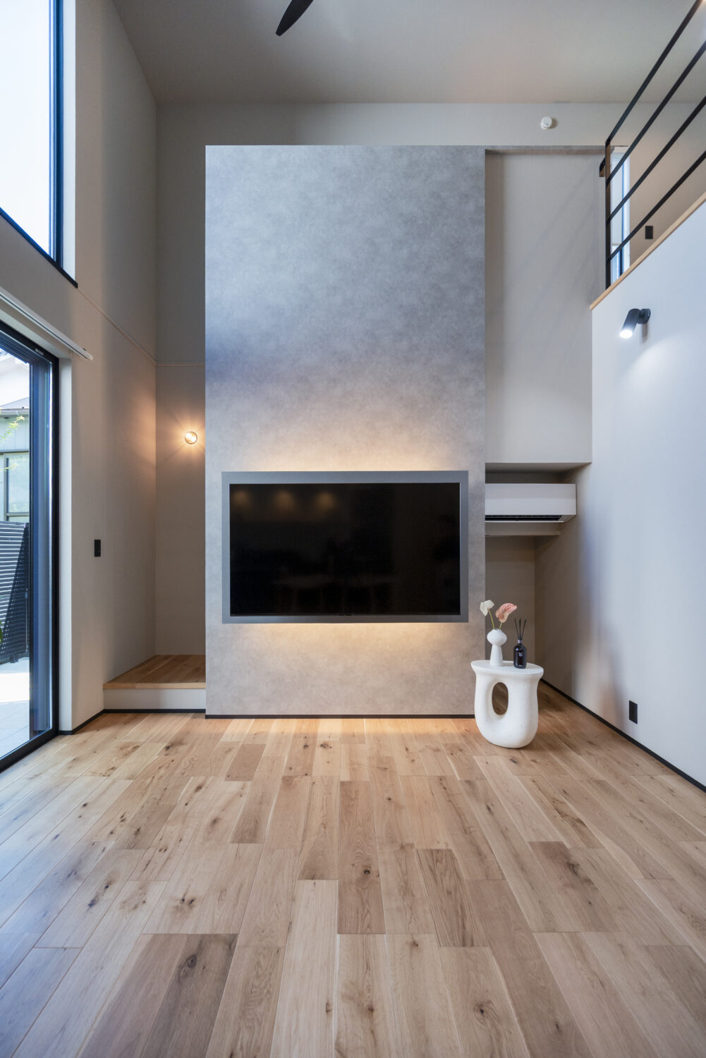 夫婦の好きを取り入れた 1階完結型のホテルライクな家｜アイデザインホーム｜淡いグレーのアクセントウォールが目を惹く、開放感あふれるリビング。