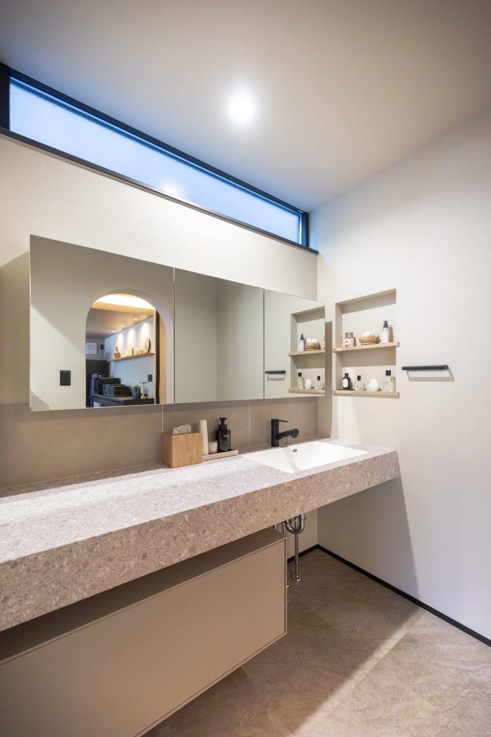 夫婦の好きを取り入れた 1階完結型のホテルライクな家｜アイデザインホーム｜石目柄のメラミンカウンター(アイカ工業)の下にはフロート収納(ミラタップ)を組み合わせ、洗練された造作洗面台に仕上げています