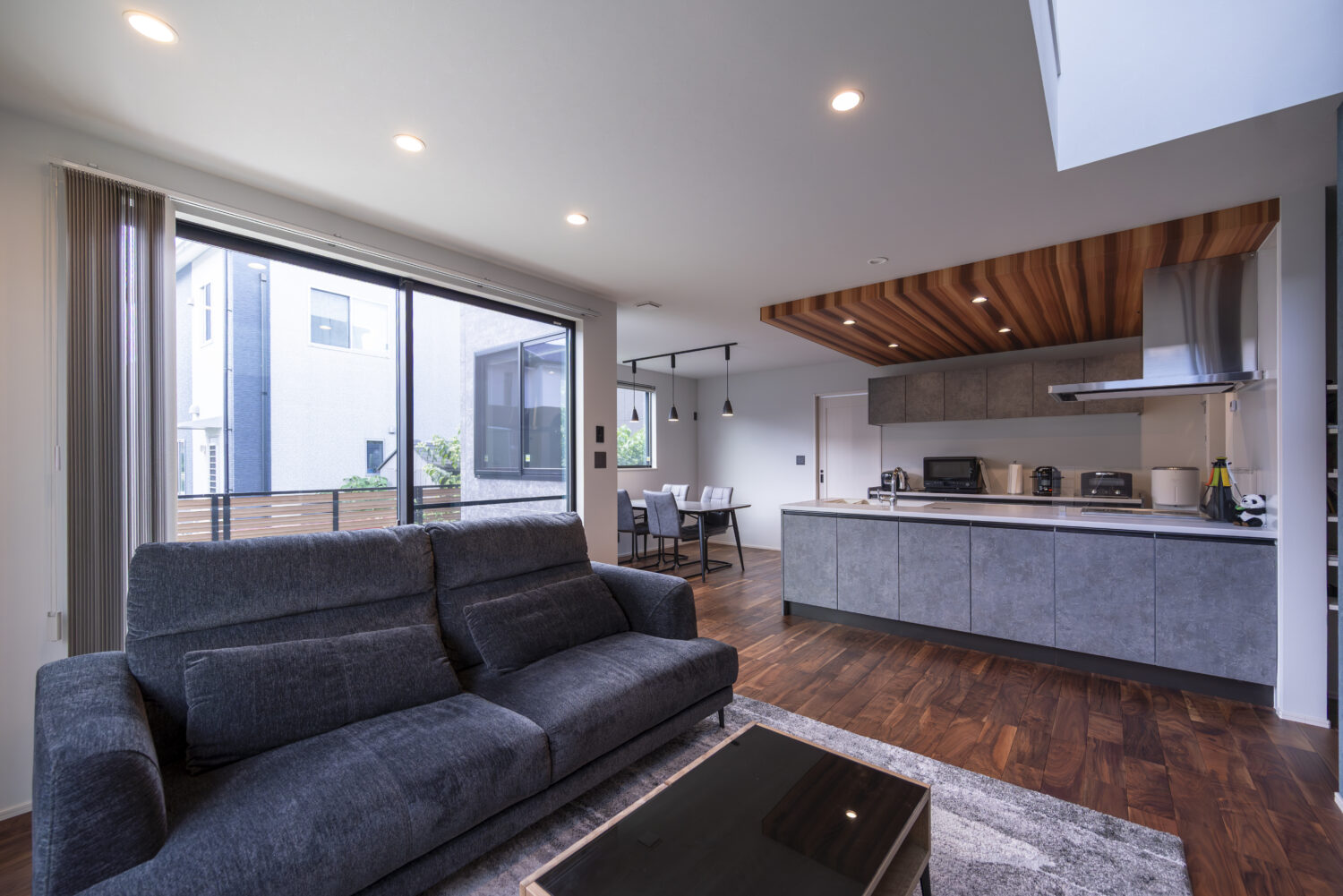 グレーを基調とした室内に、ブラックウォルナットの無垢床を取り入れたLDK｜回遊動線とスキップフロアで 家族の時間が広がる家｜アイデザインホームの実例集