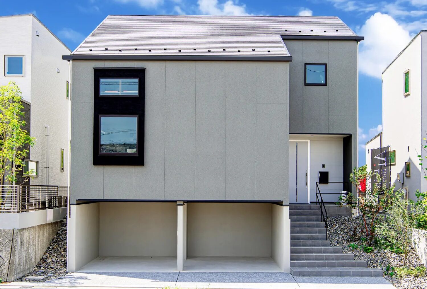 アイデザインホームのこころ展示場|グレーを基調とした外壁で2台分のビルトインガレージのあるモデルハウス