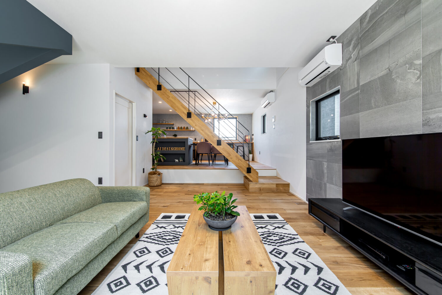 アイデザインホームのこころ展示場|リビングとダイニングキッチンの間に吹抜のあるスケルトン階段を挟んでいる