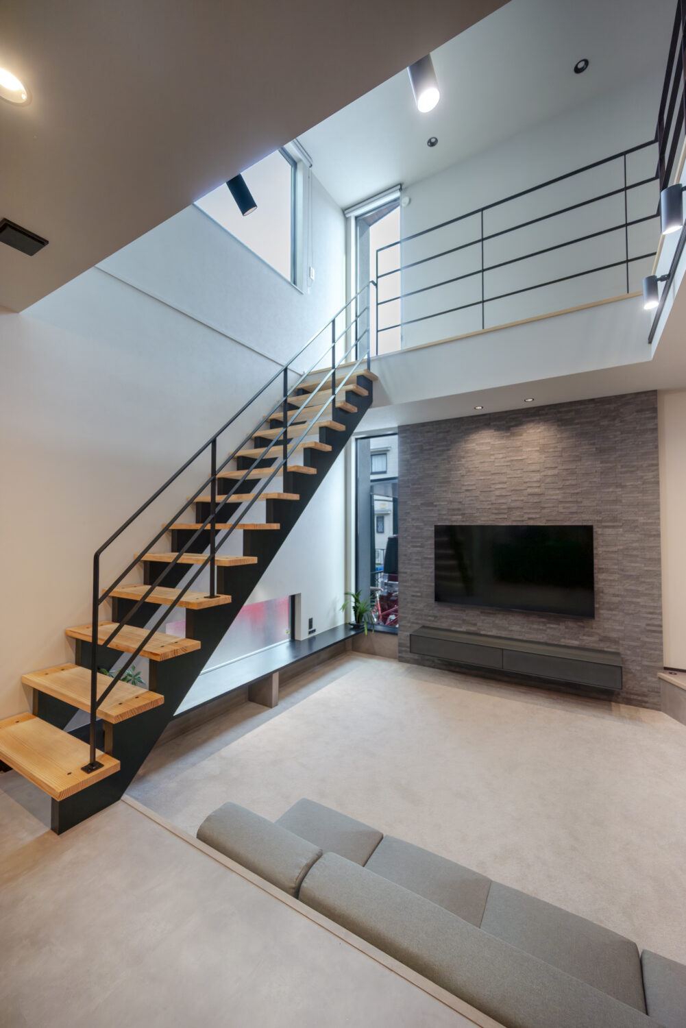 吹抜けのFIX窓から自然光が降り注ぐ、明るく開放的なピットリビング｜アイデザインホームの施工事例